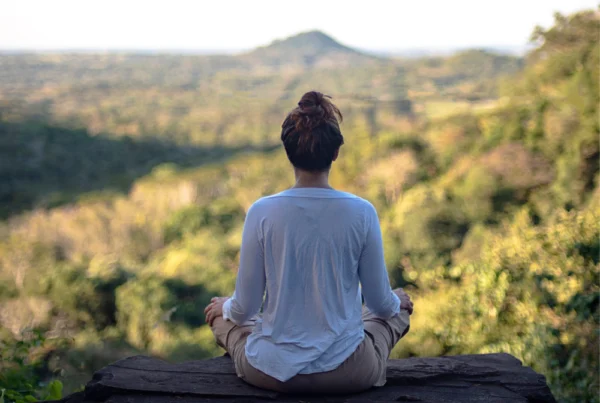 Persona meditando en la montaña encontrando su verdadero ser en la naturaleza