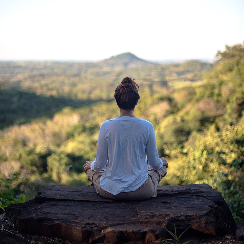 Persona meditando en la montaña encontrando su verdadero ser en la naturaleza
